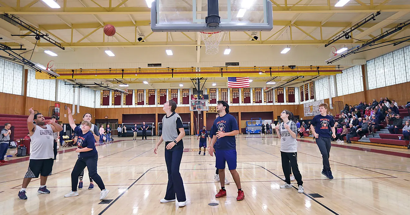 Weymouth player Vinny Marques, left, scores for the Wildcats as the Weymouth High Unified Basketball team hosts Walpole